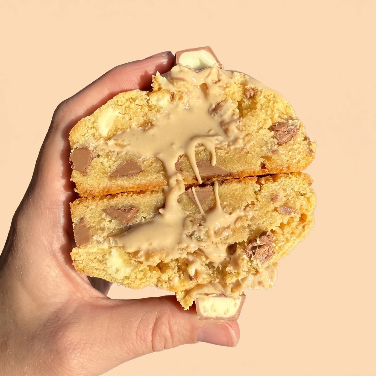 Kinder Bueno cookie cut in half, showing a Bueno spread centre and white and milk chocolate chips